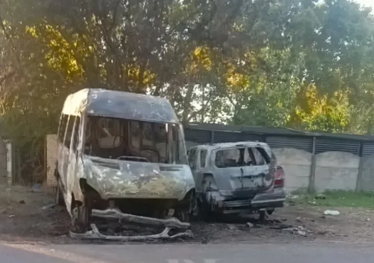 Vehículo incendiado en la vía pública de un barrio de Rosario, con presencia de bomberos.