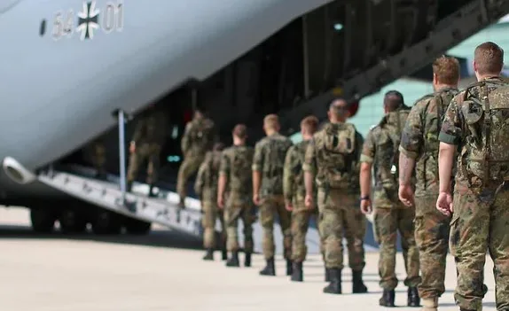 Bandera de Alemania ondeando junto a un símbolo militar genérico.