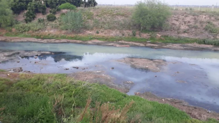 Vista del arroyo Ludueña en Rosario, donde se observa el agua de color oscuro.