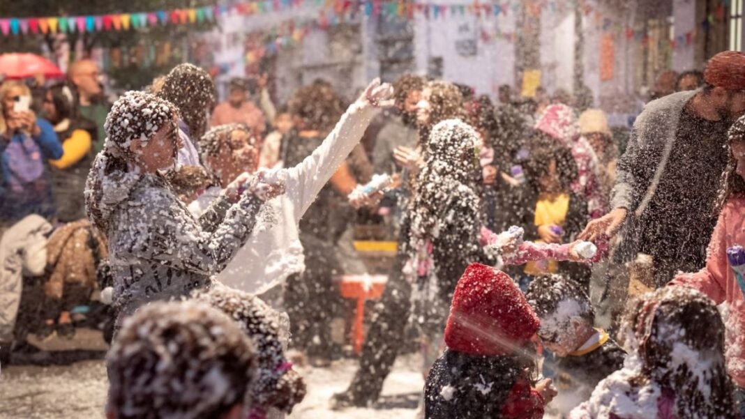 Celebración de carnaval en la calle del barrio Abasto, Santa Fe, con bandas en vivo y vecinos disfrutando.