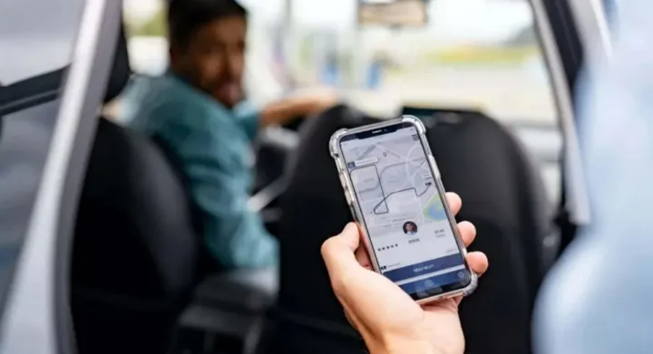 Conductores de aplicaciones de transporte conversando junto a un auto