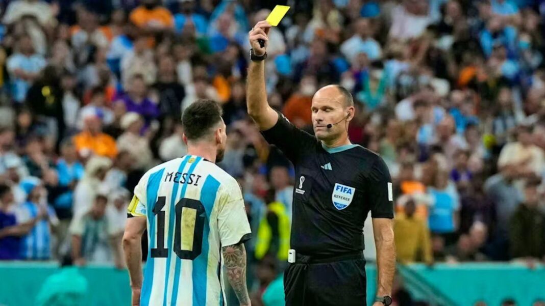 Árbitro mostrando tarjeta amarilla en partido de fútbol