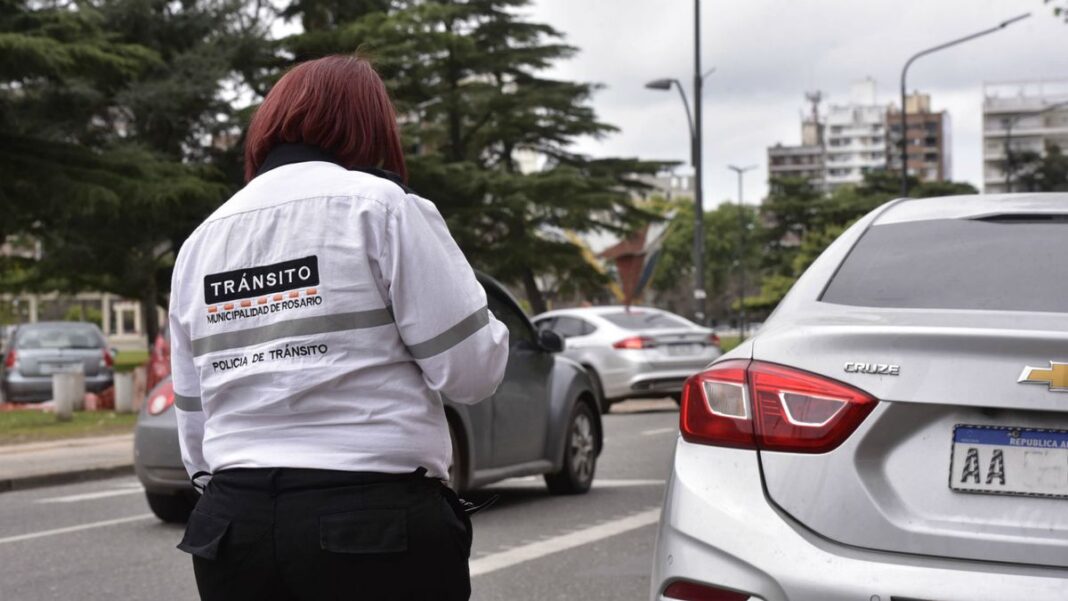 Agente de tránsito en Rosario junto a señalética vial