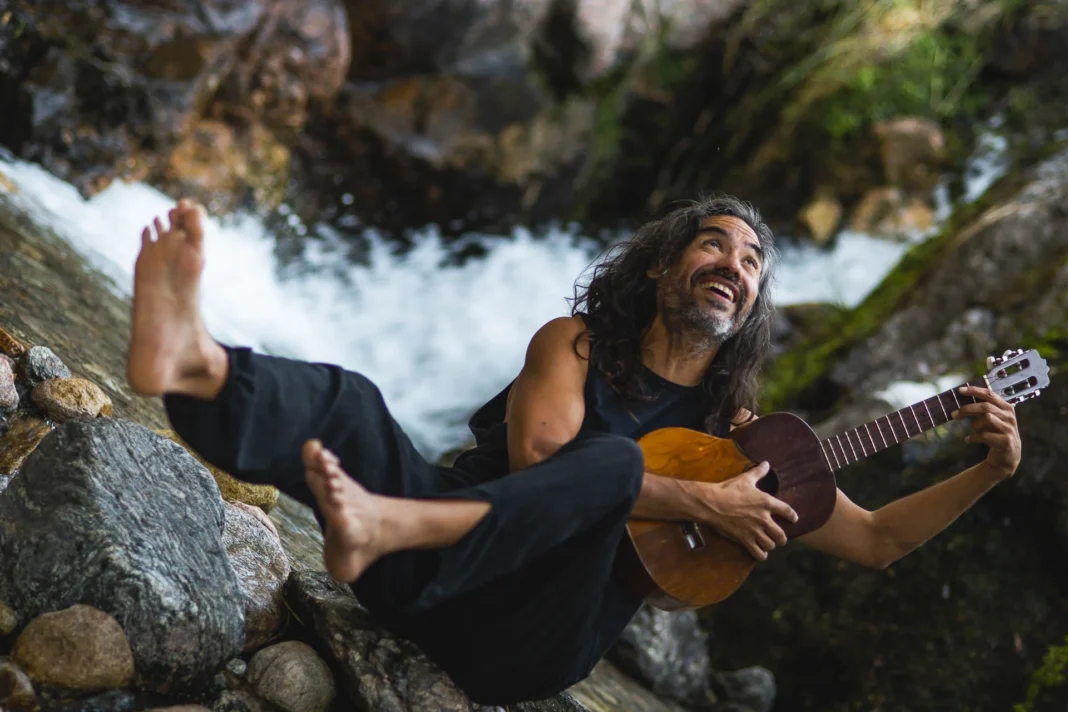 José Luis Aguirre en concierto, guitarra en mano, durante una presentación musical.