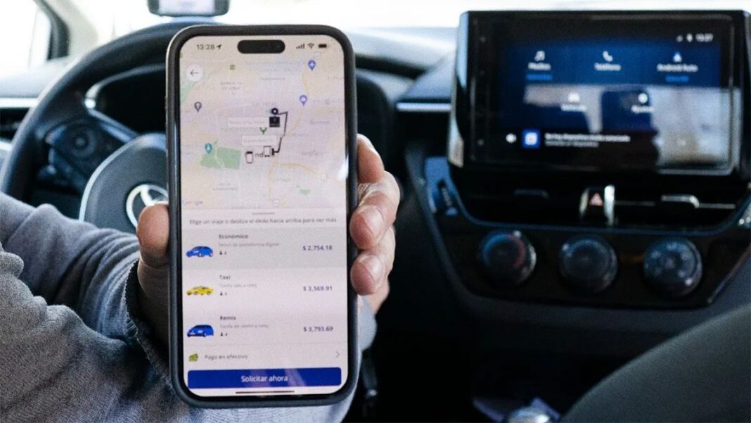 Taxis estacionados en una calle de Rosario, con un teléfono mostrando una aplicación de viajes.