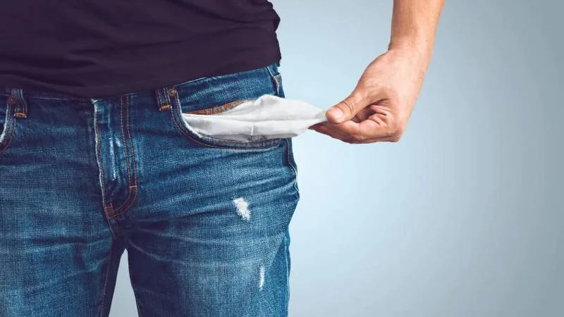 Trabajador en oficina con expresión de reflexión, rodeado de elementos que simbolizan salario emocional y beneficios laborales