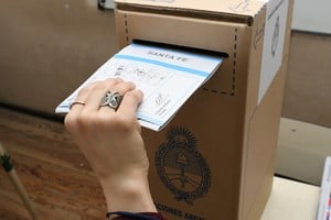 Jóvenes votando en una escuela, con urnas y boletas, simbolizando la participación electoral juvenil