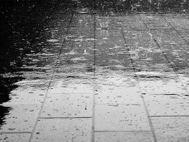 Calle de Rosario bajo la lluvia con nubes oscuras de tormenta