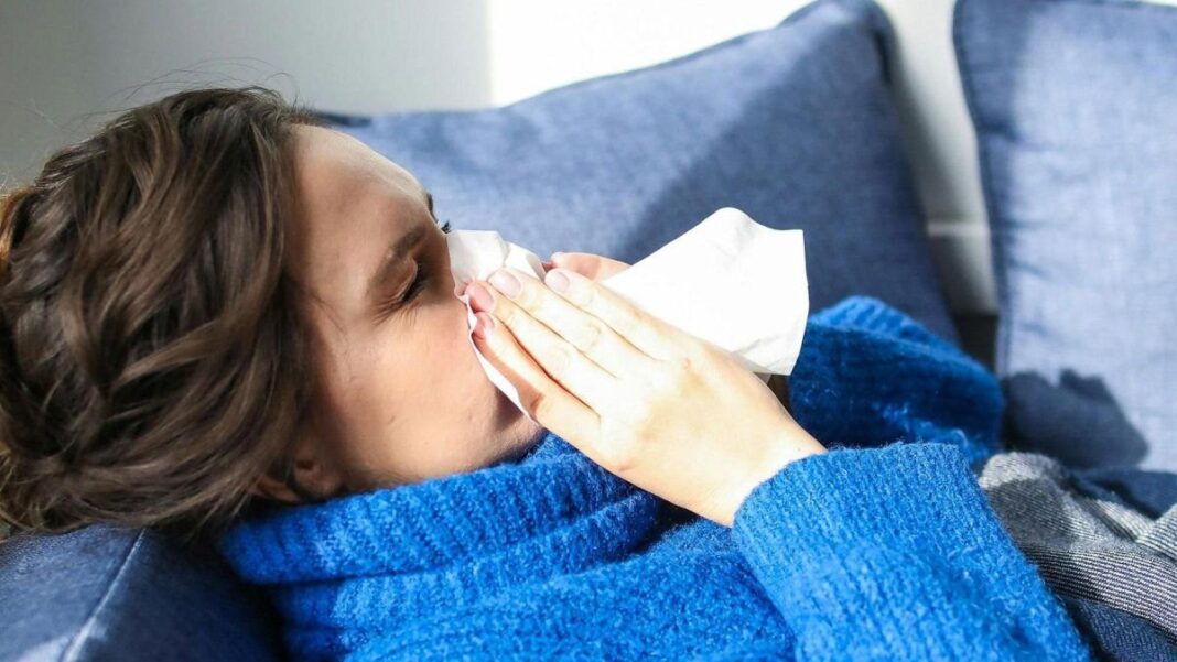 Persona con barbijo y síntomas de gripe