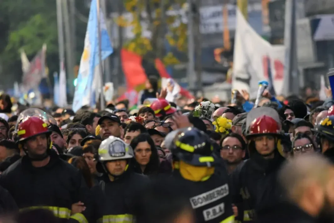 Multitud de personas reunidas en una calle durante el homenaje al Indio Solari
