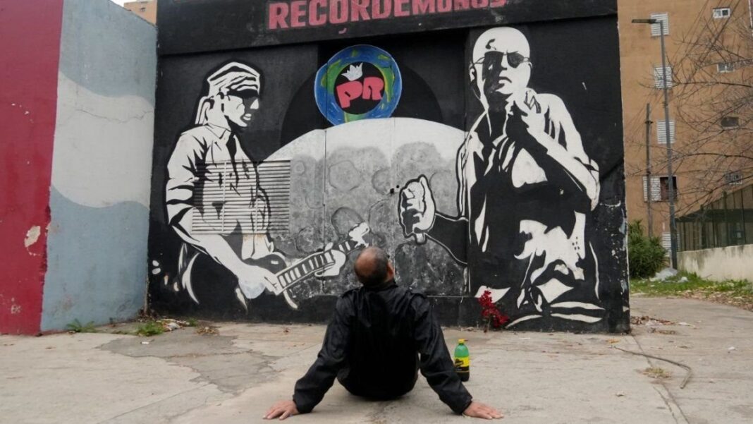 Mural del Indio Solari en el barrio Latinoamérica de Rosario con una flor roja a sus pies