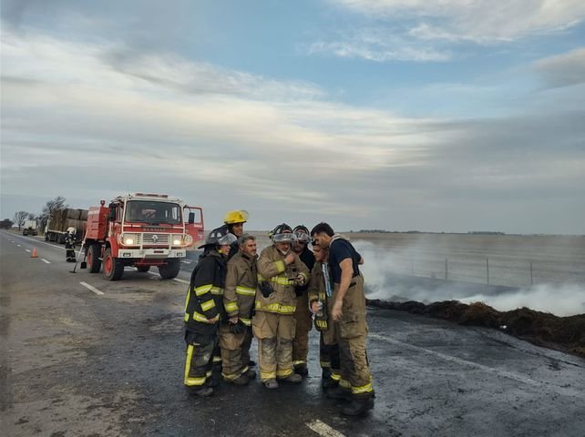 Bomberos voluntarios de María Juana posan junto a una camiseta argentina tras controlar un incendio