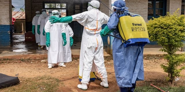 Personal sanitario se desinfecta al salir de la zona de aislamiento por ébola en el hospital local de Mongbwalu, RDC