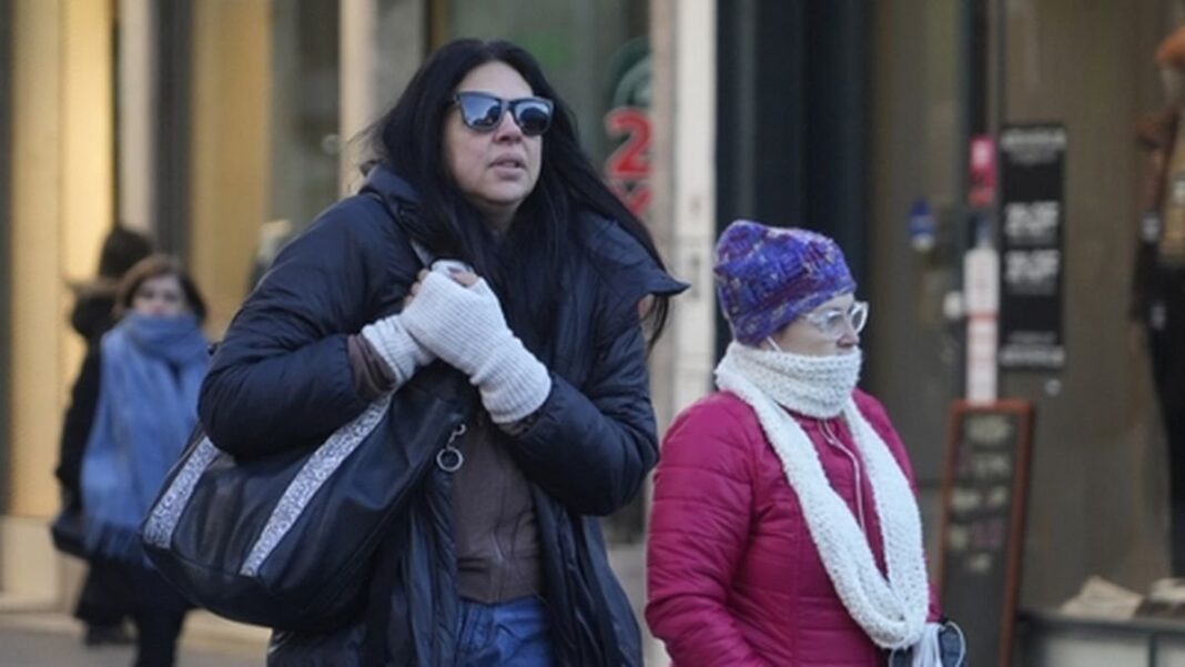 Personas abrigadas caminan por la calle en un día frío en Rosario