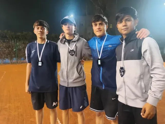 Partido de tenis de menores en cancha de polvo de ladrillo