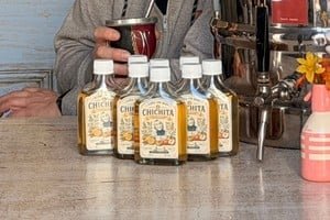 Botella de caña con ruda sobre una mesa en barrio Candioti