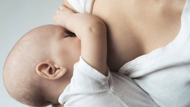 Médico explicando la relación entre lactancia y cáncer de mama