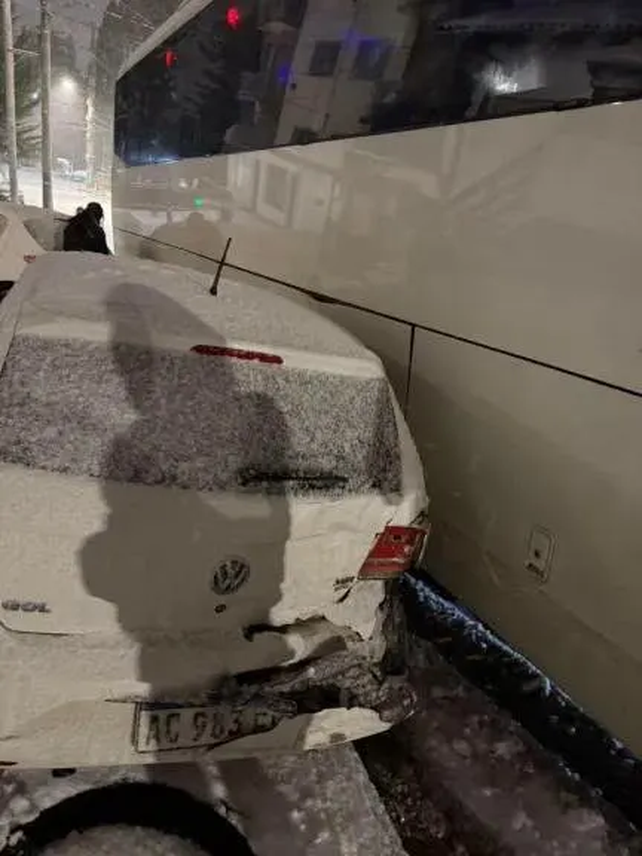 Micro de egresados derrapado en una calle nevada de Bariloche con autos dañados