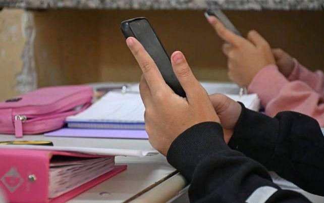Persona usando el celular en la cama por la noche