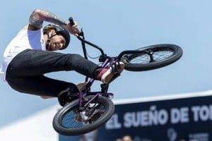 Rider de BMX freestyle realizando un truco en una rampa durante una competencia