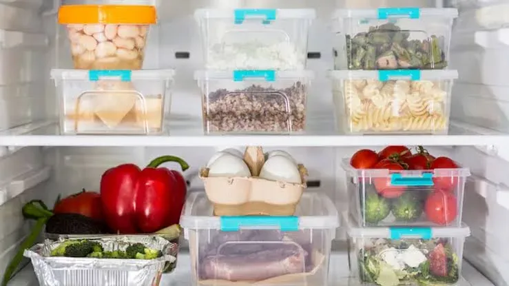 Heladera abierta con alimentos organizados en estantes y cajones