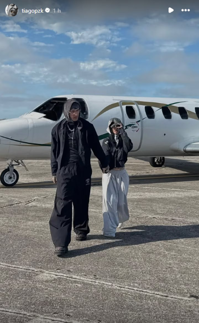 Tiago PZK y La Joaqui tomados de la mano bajando de un avión