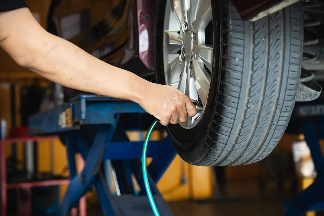 Persona inflando un neumático de auto en una estación de servicio